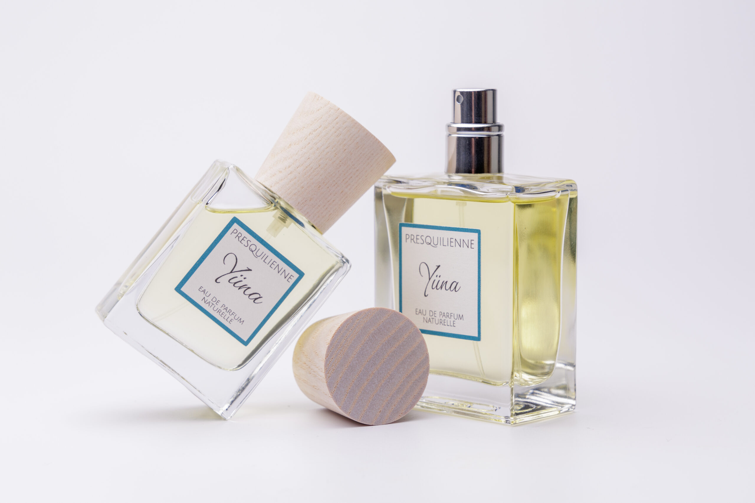 Flacon du parfum artisanal Yüna ouvert avec son vaporisateur et son bouchon en bois naturel.